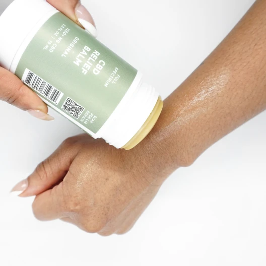 Hand applying cannabis-infused cream to the wrist skin
